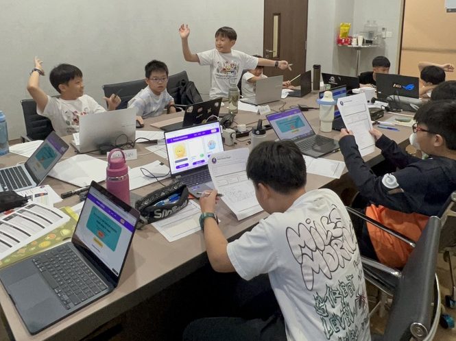 A room of campers heads-down building their apps on laptops